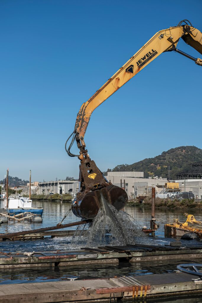 Dynamic capture of a crane lifting water at an industrial harbor setting.